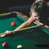 Young attractive woman playing pool in bar